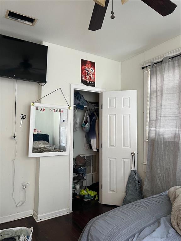 bedroom featuring ceiling fan, dark hardwood / wood-style floors, and a closet