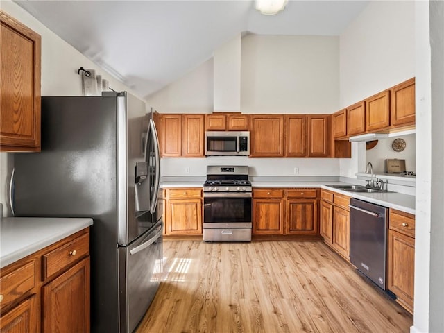 kitchen featuring high vaulted ceiling, stainless steel appliances, sink, and light wood-type flooring