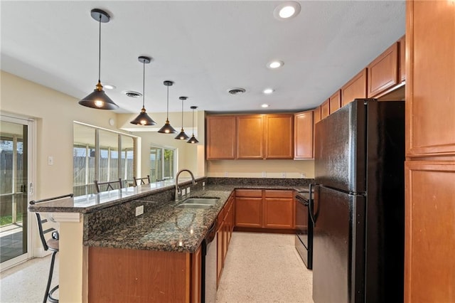 kitchen featuring hanging light fixtures, a kitchen bar, sink, kitchen peninsula, and black appliances