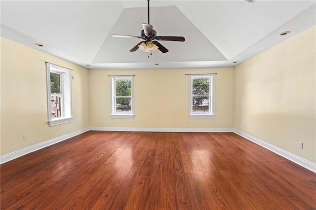 spare room with hardwood / wood-style flooring, a raised ceiling, a healthy amount of sunlight, and ceiling fan