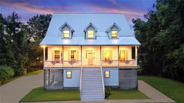 view of front of property with covered porch and a yard