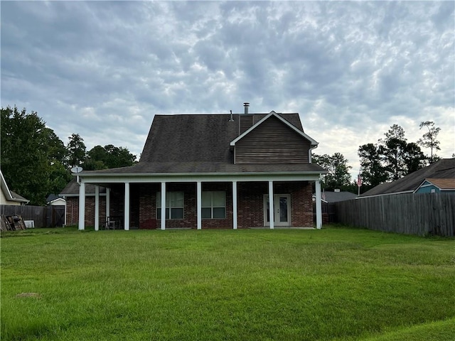 back of house featuring a fenced backyard, a lawn, and brick siding