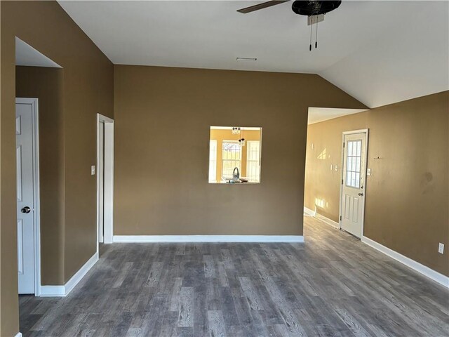 empty room featuring ceiling fan, a wealth of natural light, vaulted ceiling, and wood-type flooring