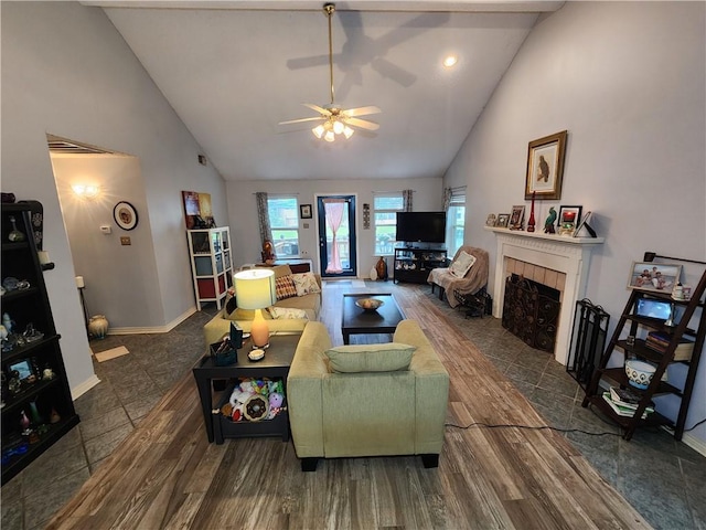 living room with a tiled fireplace, high vaulted ceiling, and hardwood / wood-style flooring