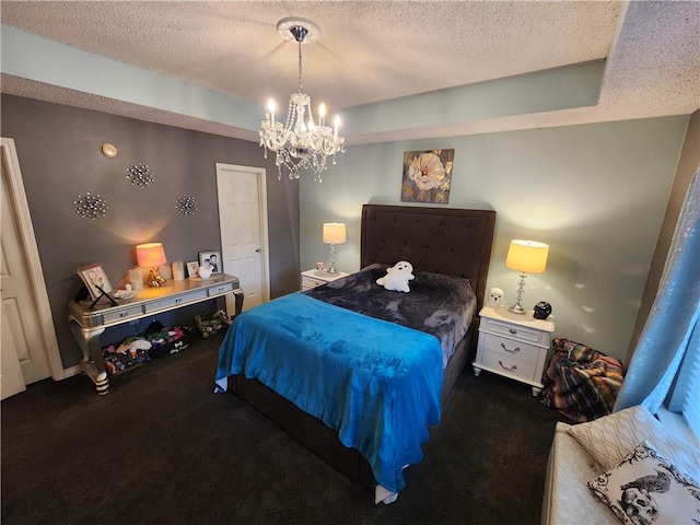 bedroom featuring dark carpet, a textured ceiling, and a chandelier