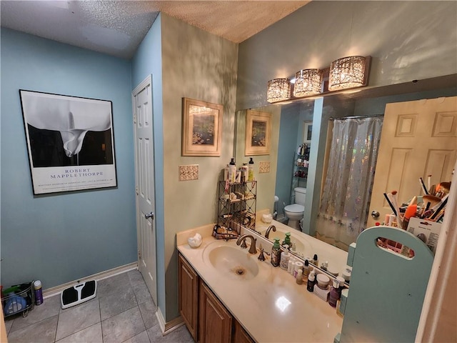 bathroom with vanity, toilet, a textured ceiling, and tile patterned floors