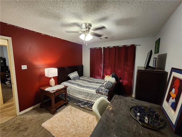 bedroom featuring a textured ceiling, carpet, and ceiling fan