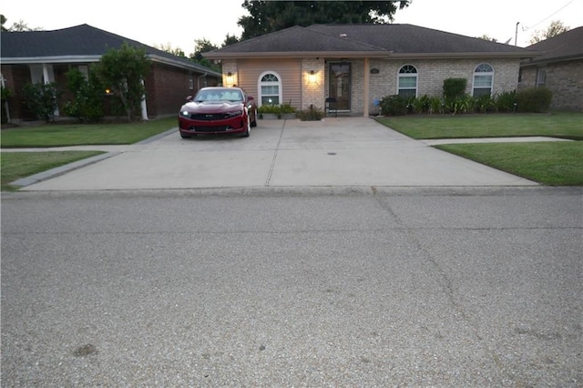 ranch-style house with a front yard and brick siding