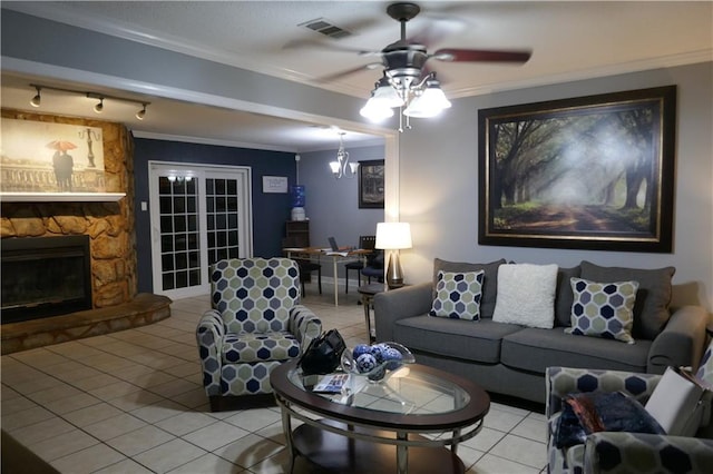 living room with crown molding, a fireplace, visible vents, a ceiling fan, and light tile patterned flooring