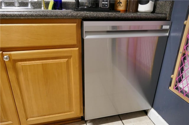 details featuring stainless steel dishwasher, dark countertops, and a sink