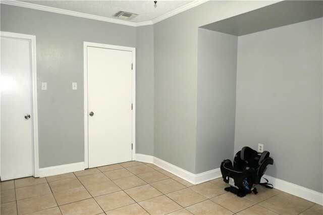 empty room featuring ceiling fan, light tile patterned floors, and ornamental molding