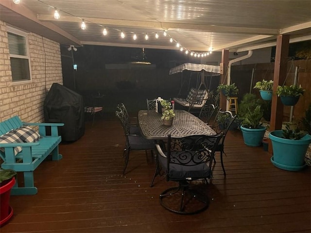 deck with a grill and outdoor dining area