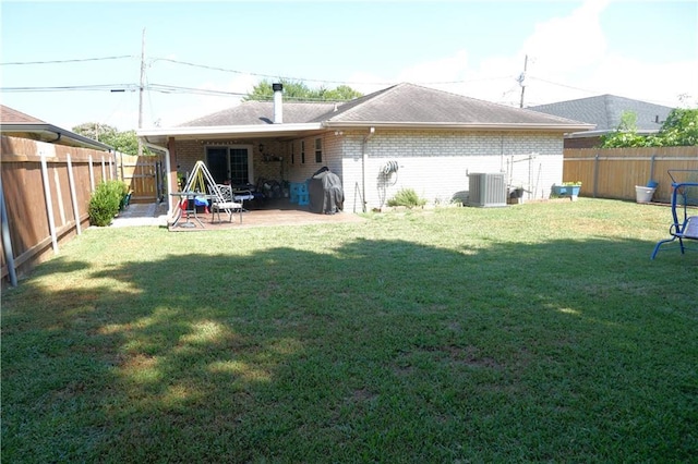 rear view of property with cooling unit, brick siding, and a lawn