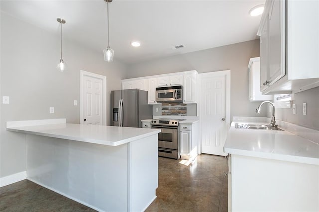 kitchen featuring stainless steel appliances, dark tile patterned floors, sink, pendant lighting, and white cabinets