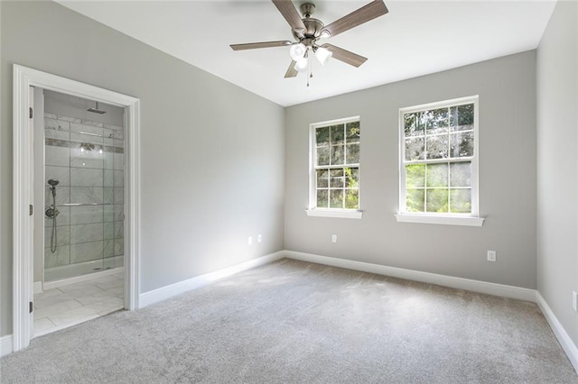 unfurnished bedroom featuring light colored carpet, connected bathroom, and ceiling fan