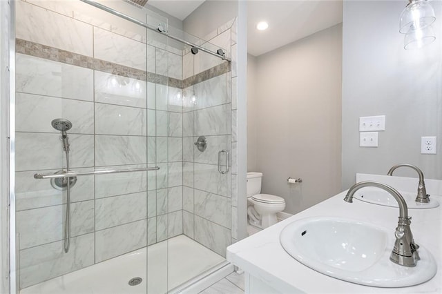 bathroom with tile patterned floors, a shower with shower door, vanity, and toilet