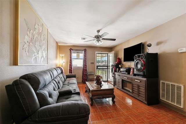 living room featuring ceiling fan and parquet floors