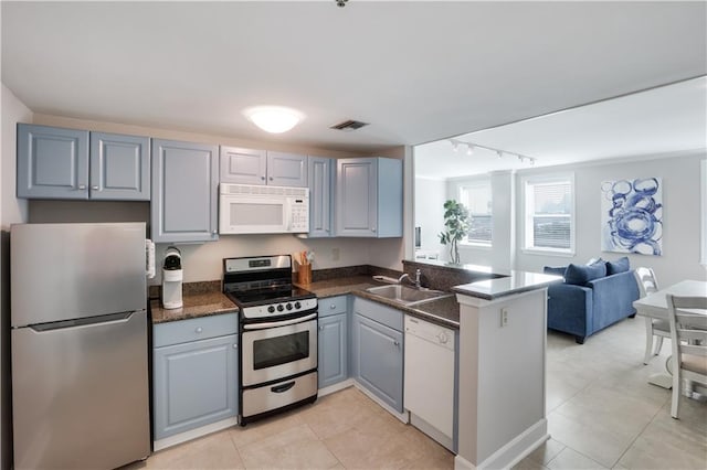 kitchen featuring light tile patterned floors, kitchen peninsula, stainless steel appliances, and sink