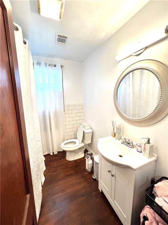 bathroom featuring toilet, vanity, and wood-type flooring