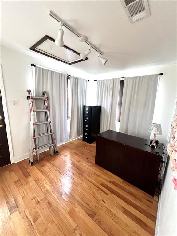 bedroom featuring track lighting and light hardwood / wood-style flooring