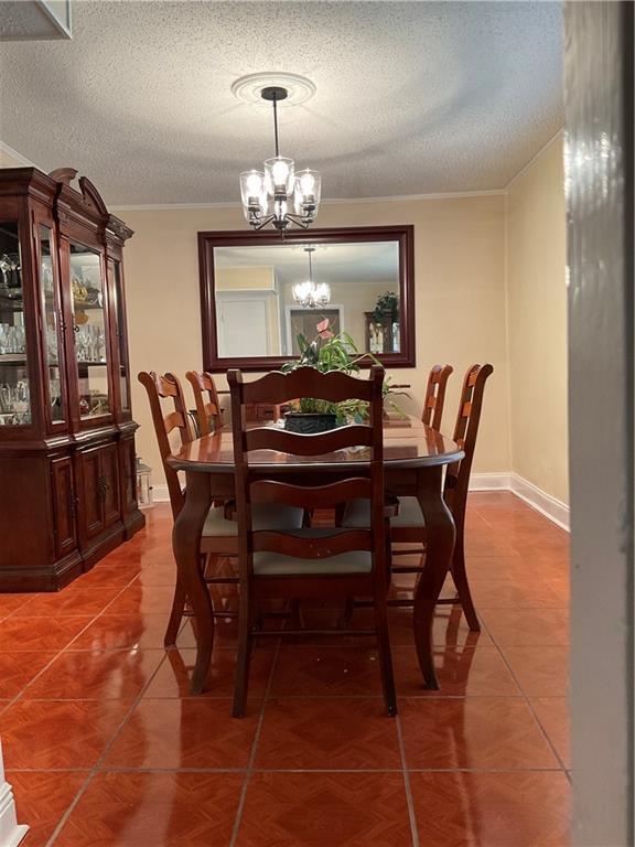 tiled dining area featuring a textured ceiling and a notable chandelier