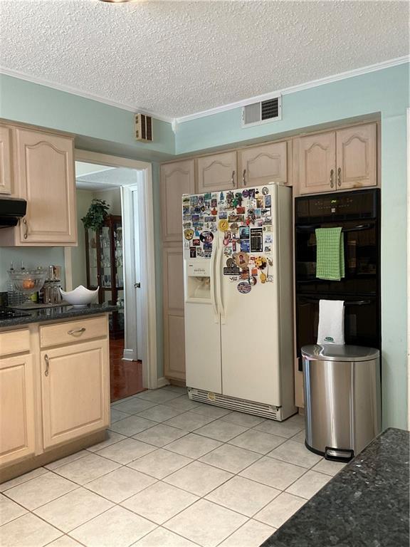 kitchen featuring ornamental molding, a textured ceiling, range hood, and white refrigerator with ice dispenser