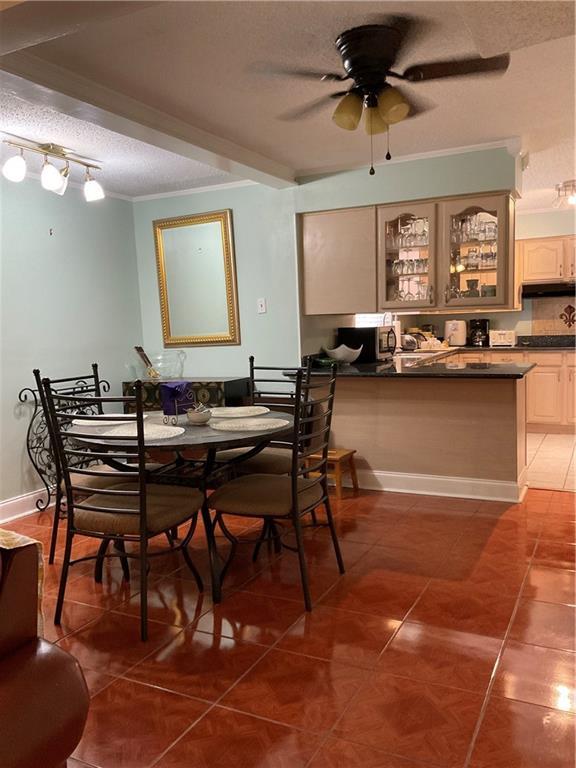 dining area with a textured ceiling, ceiling fan, track lighting, and tile patterned floors