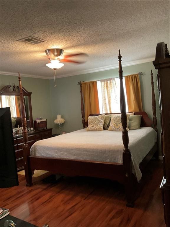 bedroom featuring a textured ceiling, ceiling fan, ornamental molding, and wood-type flooring