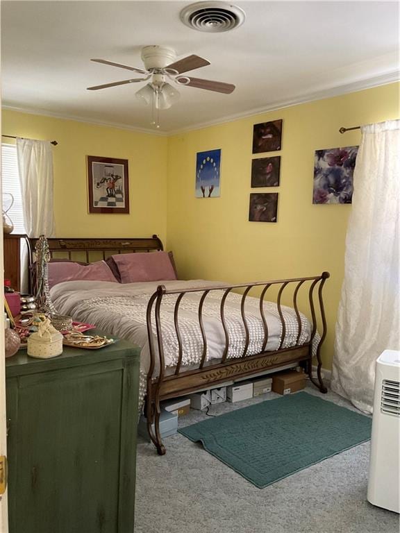 carpeted bedroom featuring ceiling fan and ornamental molding