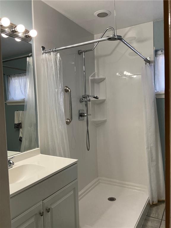 bathroom with tile patterned floors, curtained shower, and vanity