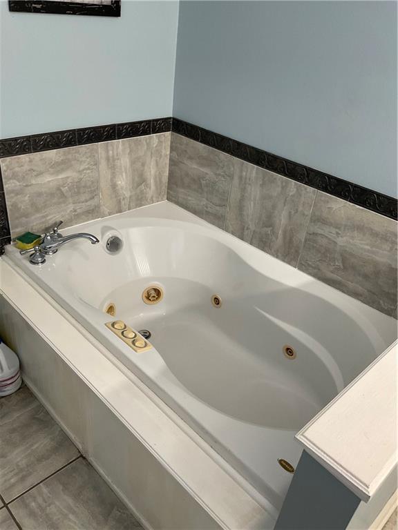 bathroom featuring tile patterned floors and a bathtub