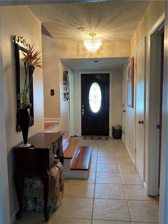 entrance foyer featuring a textured ceiling and an inviting chandelier