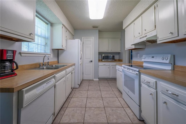 kitchen with sink, white appliances, white cabinets, and light tile patterned floors