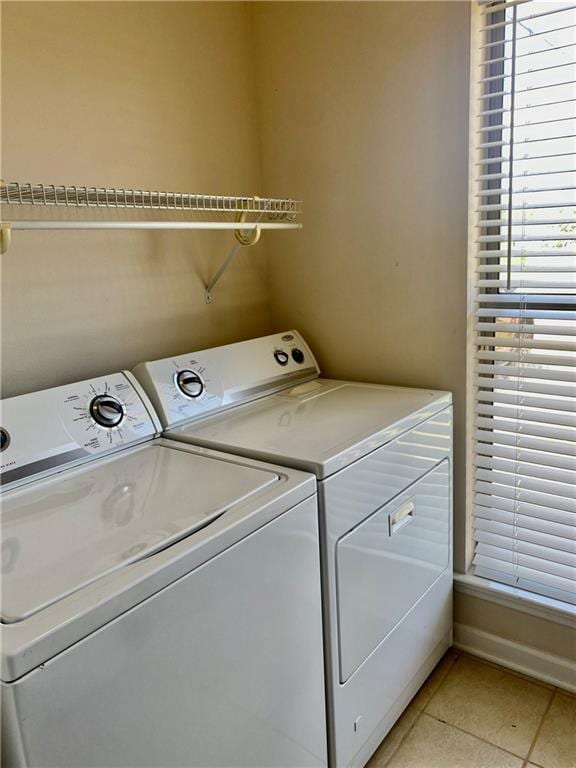 laundry area with laundry area, light tile patterned floors, baseboards, and independent washer and dryer