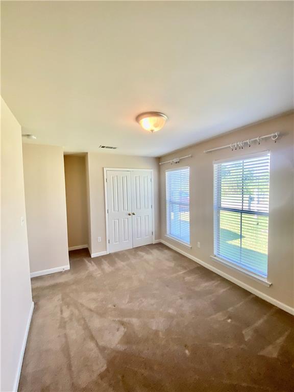 empty room featuring carpet floors and baseboards