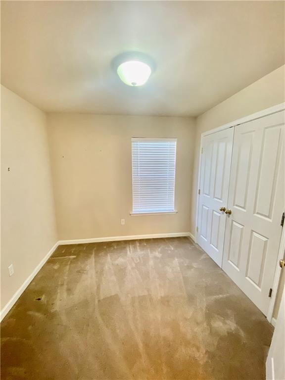 interior space with carpet floors, baseboards, and a closet