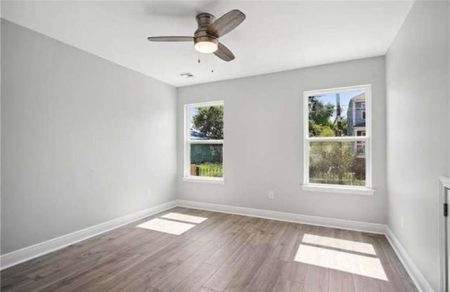 unfurnished room with ceiling fan and hardwood / wood-style flooring