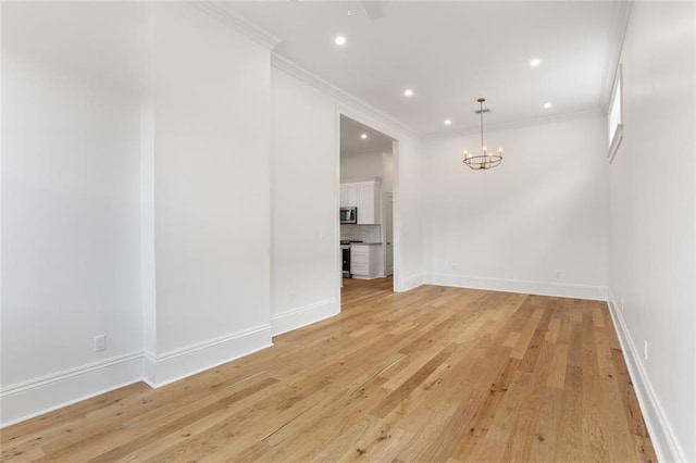 unfurnished room with a chandelier, light hardwood / wood-style flooring, and ornamental molding