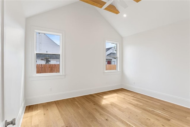 spare room with ceiling fan, lofted ceiling with beams, and light wood-type flooring