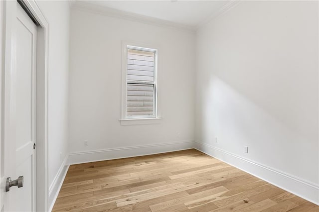 empty room with crown molding and light wood-type flooring