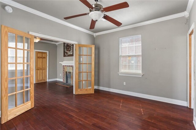 unfurnished room with ceiling fan, dark hardwood / wood-style flooring, crown molding, and a brick fireplace