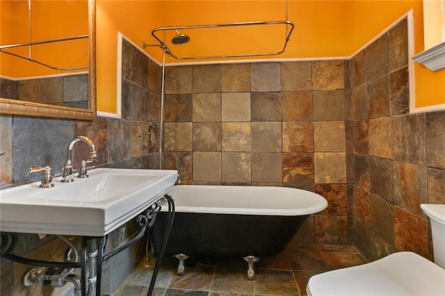 2546 Elder St, New Orleans, LA 70122 - bathroom with tile walls, toilet, and a freestanding bath
