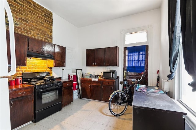 kitchen with light tile patterned floors, dark brown cabinetry, and black range with gas stovetop