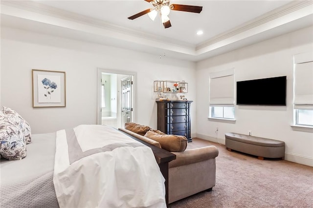 bedroom with multiple windows, ensuite bathroom, a tray ceiling, and ceiling fan