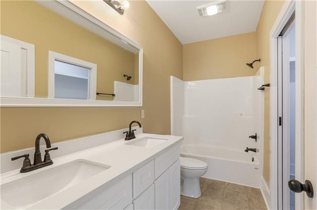 full bathroom featuring tile patterned flooring, toilet, vanity, and shower / washtub combination