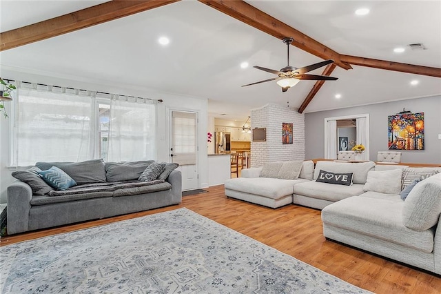 living room with vaulted ceiling with beams, light hardwood / wood-style floors, and ceiling fan