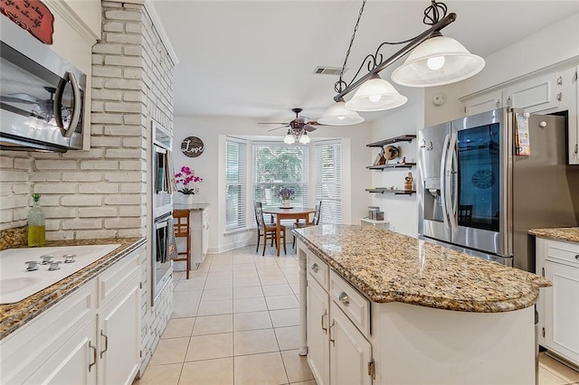 kitchen featuring pendant lighting, a center island, light tile patterned flooring, white cabinetry, and stainless steel appliances