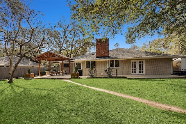 rear view of property featuring a yard, french doors, and a patio area