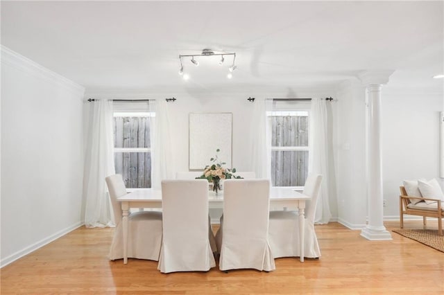 dining space featuring a healthy amount of sunlight, track lighting, light hardwood / wood-style flooring, and ornamental molding