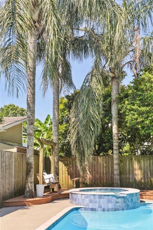 view of swimming pool featuring an in ground hot tub